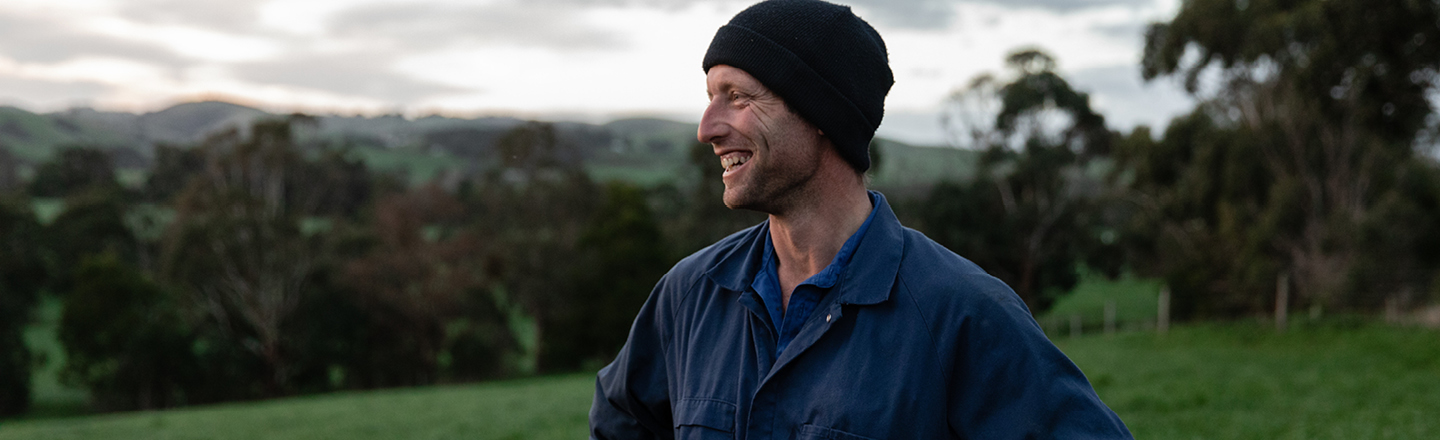 Smiling farmer standing in lush field