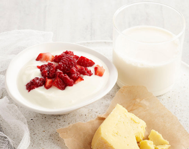 Glass of milk, yogurt with red berries and a slice of cheese